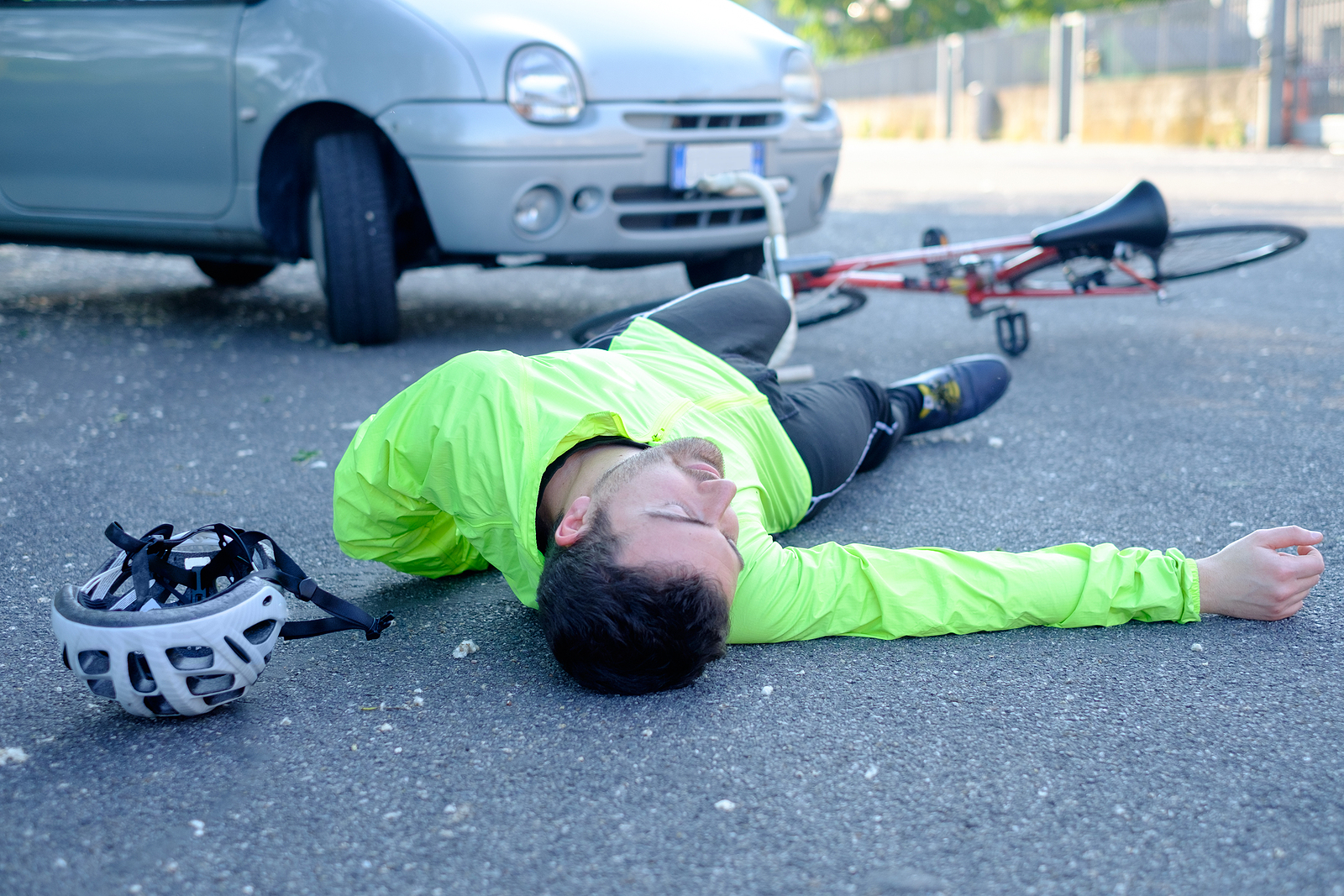 fainted aching man after bicycle accident on the asphalt