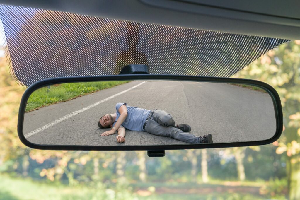 man lying in the road after being hit by a car