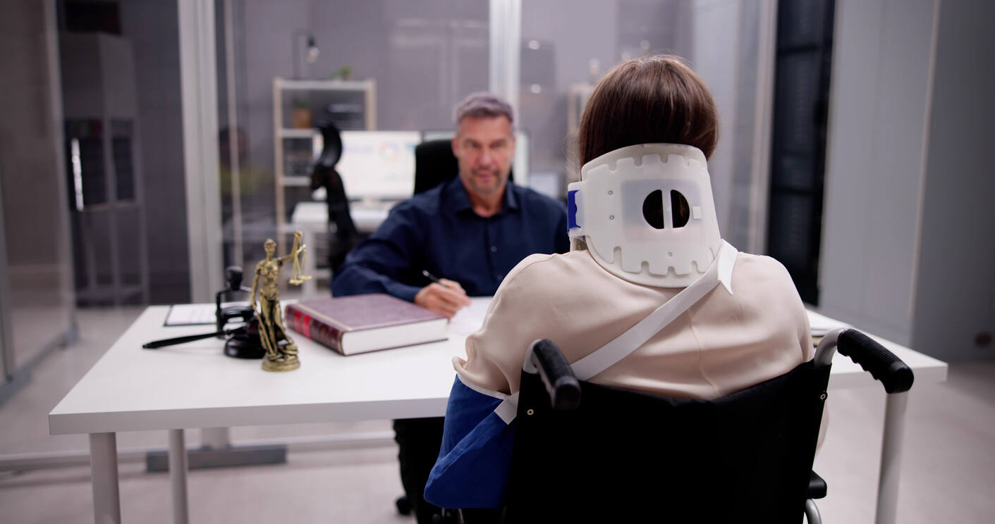 Injured client in neck brace speaking with a Colorado Springs premises liability lawyer