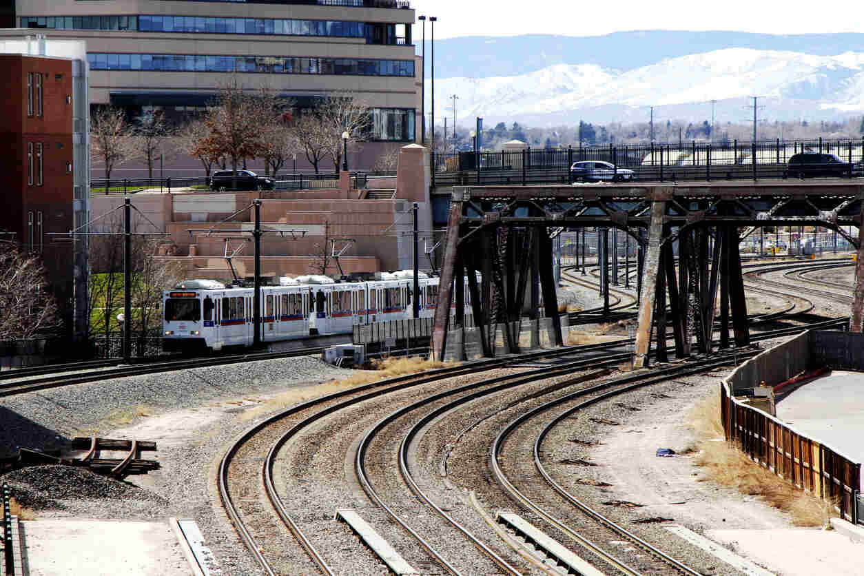 An urban light rail system with multiple tracks and elevated bridges in denver, depicting a potential location for a train accident.